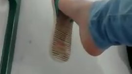 Candid teen dangling flat flip flops in the school